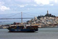 Suspension sections of Oakland Bay Bridge, Coit Tower & container ship. San Francisco, CA.