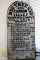 Wooden sign with toll gate rates for road crossing Ebbetts Pass owned by Big Tree & Carson Valley Turnpike Co. at Calaveras County Downtown Museum. San Andreas, CA.