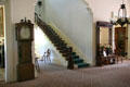 Stairway beside tall clock & hall mirror at Bidwell Mansion house museum. Chico, CA.