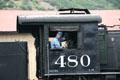 Engineer waving from cab of Durango & Silverton locomotive 480. Durango, CO.