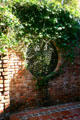 Round window in garden wall at Old St. Augustine Village. St Augustine, FL.