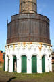 Water tanks at base of smokestack captured waste heat to provide workers with washing facilities in cubicles preserved at Roundhouse Railroad Museum. Savannah, GA.