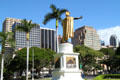 Statue of King Kamehameha I against downtown Honolulu skyline. Honolulu, HI.