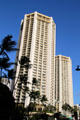 Octagonal twin Hyatt Regency Waikiki Towers over palms. Waikiki, HI.