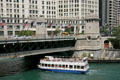 Tour boat passes under Michigan Avenue Bridge over Chicago River. Chicago, IL.