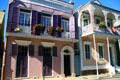 Purple house & house with balcony over sidewalk. New Orleans, LA.