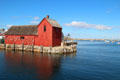 Red building with floats serves as symbol of Rockport. Rockport, MA.