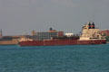Great Lakes freighter American Courage passes Detroit Free Press building on Detroit River. MI.