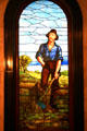 Stained glass window of pioneer felling tree on stairwell of Mississippi State Capitol. Jackson, MS.