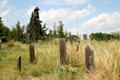 Statue of cowboy & prairie grasses surround wooden tombstones on Boot Hill Cemetery. Ogallala, NE.