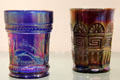 Carnival Glass tumblers blue peacock at fountain & purple Greek key both by Northwood Glass Co. at Museum of American Glass. Milville, NJ.