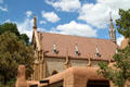 Roofline of Loretto Chapel over adobe-style building. Santa Fe, NM.