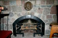 Fireplace with seahorse andirons under plaque to William Morris, founder of the Arts & Crafts movement, in Roycroft Museum. East Aurora, NY.