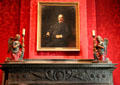 Fireplace carved mantel holding Pierpont Morgan portrait plus kneeling angel candlesticks from Italy at Morgan Library. New York City, NY.