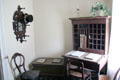 Cubbyhole desk beside hat rack with mirror in Layton Home at Old Bethpage Village. Old Bethpage, NY.