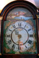 Ornate face of pendulum wall clock with painted rural scene at Home Sweet Home Museum. East Hampton, NY.
