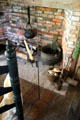 Brick fireplace with antique implements plus adjustable height candlestick at Thomas Halsey Homestead. South Hampton, NY.