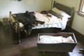 Colonial era bed with bearskin rug & cradle at Thomas Halsey Homestead. South Hampton, NY.