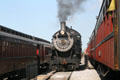 Steam locomotive #475 of Strasburg Railroad between passenger cars. Strasburg, PA