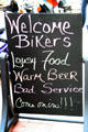 Sign welcoming bikers with Lousy Food, Warm Beer, Bad Service, Come on in. Lead, SD