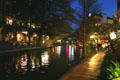 Riverwalk at night with reflections in river. San Antonio, TX.