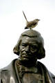 Mockingbird sits on head of statue of William Marsh Rice at Rice University. Houston, TX.