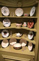 Corner cabinet with ceramic plates & bowls in Newport room at Bayou Bend. Houston, TX.