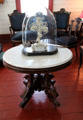 Victorian art under glass on marble-topped carved center table in Yates House at Sam Houston Park. Houston, TX.