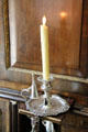 Silver candlestick on pull-on candle shelf of bureau cabinet at Rienzi house museum. Houston, TX.