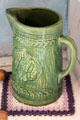 Molded green-glazed ceramic pitcher in Fassel-Roeder House at Pioneer Museum. Fredericksburg, TX.