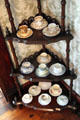 Étagère displaying fine china cups & saucers in dining room at Chambers House Museum. Beaumont, TX.
