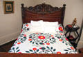Carved bed with quilt made by Mrs. Ann Rawes at McCulloch House. Waco, TX.