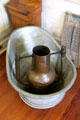 Sitting bathtub with handled vessel to hold coals for heating bath water in kitchen at French Legation Museum. Austin, TX.