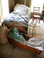 Children's bedroom with cradle in Frederick Jourdan cabin at Pioneer Farms. Austin, TX.