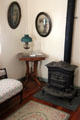 Heating stove & small square side table in parlor of Jahn House at Conservation Plaza. New Braunfels, TX.