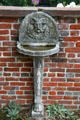 Carved fountain against wall in garden at Oatlands. Leesburg, VA.