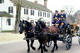 Horse drawn buggy passes John Greenhow house & store in Colonial Williamsburg. Williamsburg, VA.