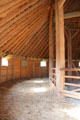 Reconstruction of barn invented by George Washington wherein hooves of horses walking in circles broke wheat kernels from straw which fell through floor for collection at Mt Vernon. Washington, VA.