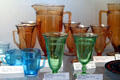 Blue, amber & green Priscilla pattern glass cups, tumblers & pitchers at Fostoria Glass Museum. Moundsville, WV.