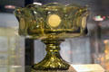 Coin glass footed compote in olive at Fostoria Glass Museum. Moundsville, WV.