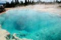 Blue of geyser pool caused by particles in water at Yellowstone National Park. WY.