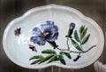 Soft-paste porcelain salad dish with purple flower & stem made in Chelsea at National Museum of Wales. Cardiff, Wales.