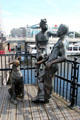 Bronze statue, "People Like Us" of man, woman & dog by John Clinch at Cardiff Bay. Cardiff, Wales.