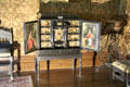 Cubby hole cabinet with paintings on front of each door in Ebony Room at Penrhyn Castle. Bangor, Wales.