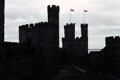 The walls & towers of Caernarfon Castle profiled against the sky. Caernarfon, Wales.