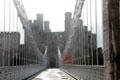 Thomas Telford's suspension bridge , one of the first road suspension bridges in the world, was designed to fit in with the architecture of Conwy Castle, the bridge towers being smaller versions of the castle towers. Conwy, Wales.