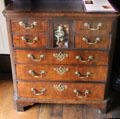 Norfolk chest of drawers with brass handles, decorative work & display niche at Plas Newydd. Llangollen, Wales.