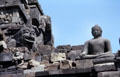 Toothed Indonesian-style mask guards a Buddha at Borobudur. Indonesia.