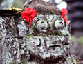 Carving of head decked with flowers. Bali, Indonesia.