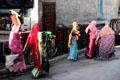 Women wearing colorful saris walk through market in Jaiselmer. India.